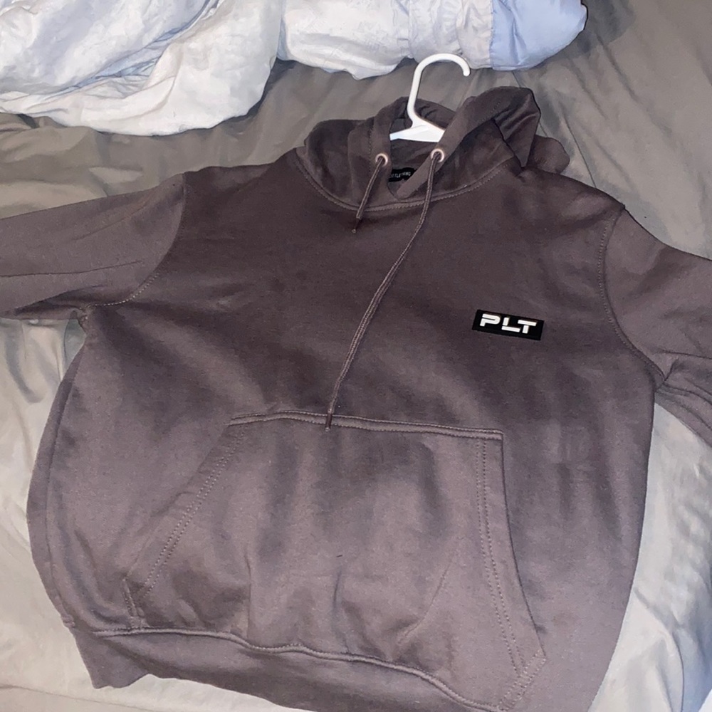 It’s a hoodie. Look brownish but under light it looks grey